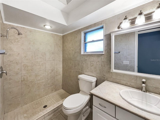 bathroom featuring vanity, tile walls, toilet, and a tile shower