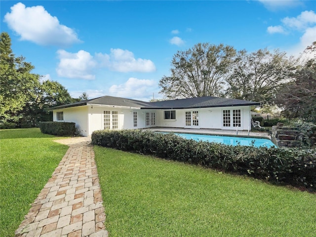 rear view of property with a lawn and french doors