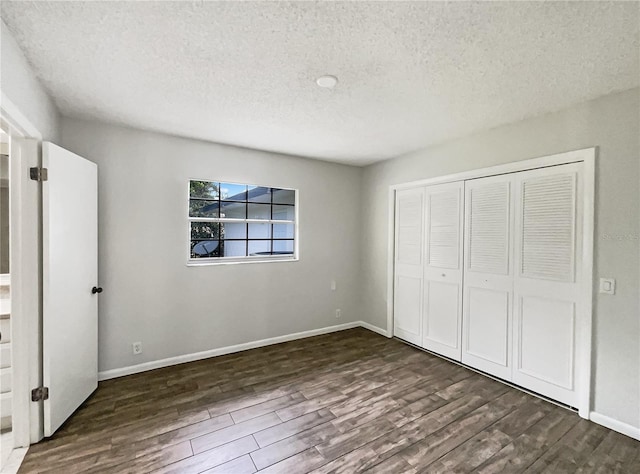 unfurnished bedroom featuring dark hardwood / wood-style flooring, a closet, and a textured ceiling