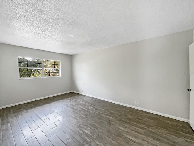 unfurnished room featuring dark hardwood / wood-style floors and a textured ceiling