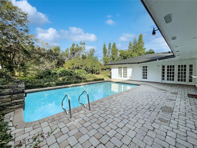 view of swimming pool with french doors and a patio