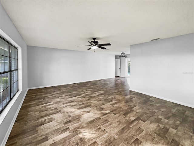 empty room featuring dark wood-type flooring and ceiling fan