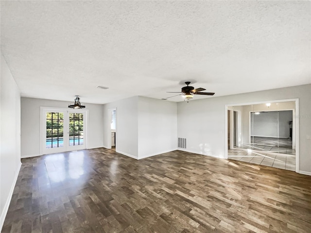 unfurnished living room featuring french doors, ceiling fan, dark hardwood / wood-style flooring, and a textured ceiling