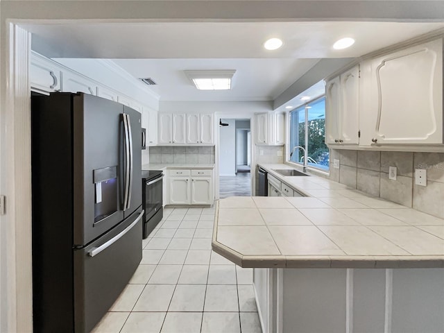 kitchen with sink, white cabinets, stainless steel fridge with ice dispenser, tile countertops, and kitchen peninsula