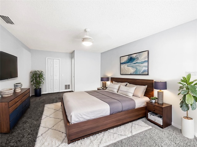 carpeted bedroom with a textured ceiling and a closet