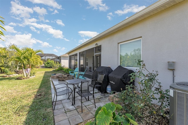 view of patio / terrace featuring central AC, a grill, and a fire pit