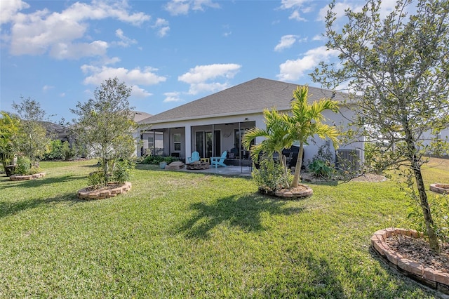 back of property with a yard and a patio