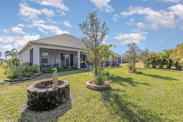 view of yard featuring a sunroom and an outdoor fire pit