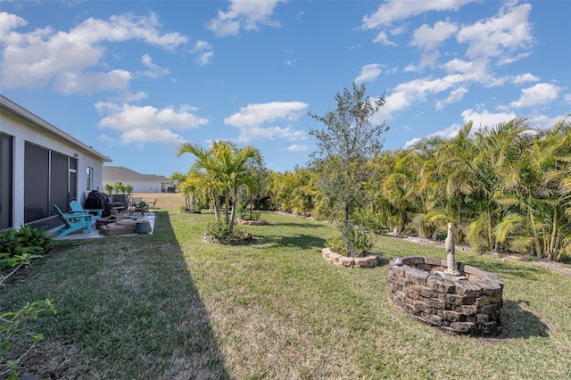 view of yard with an outdoor fire pit and a patio area