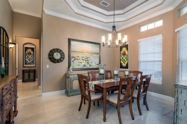 dining room with crown molding, a chandelier, and a tray ceiling