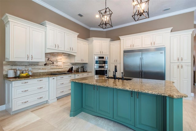 kitchen with sink, appliances with stainless steel finishes, dark stone countertops, hanging light fixtures, and an island with sink