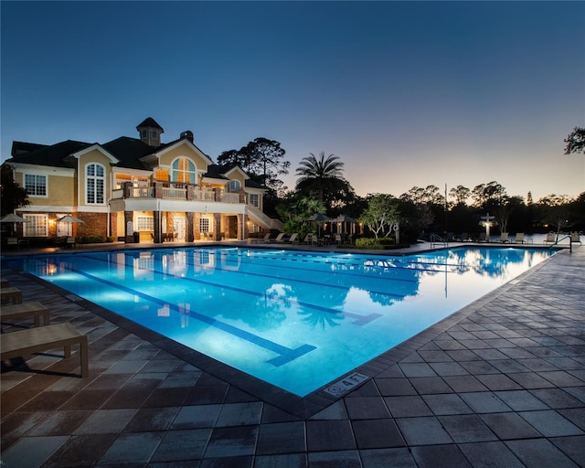 pool at dusk with a patio