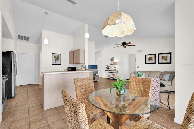 tiled dining room featuring ceiling fan and high vaulted ceiling