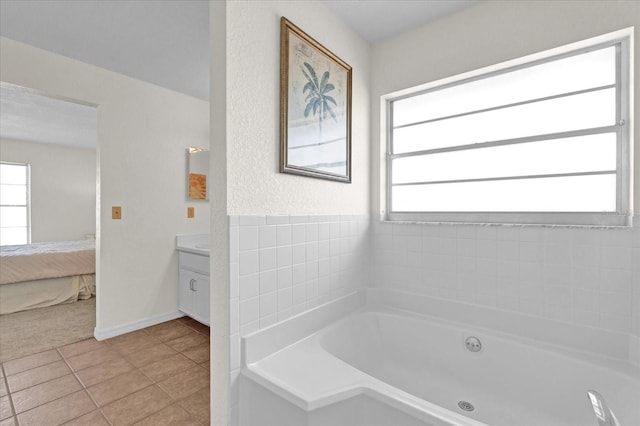 bathroom with vanity, a washtub, and tile patterned floors