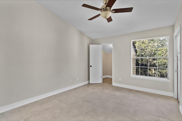 empty room with ceiling fan and light tile patterned floors