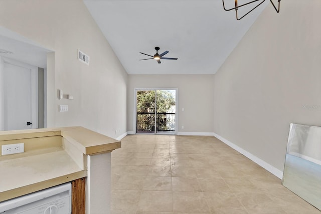 unfurnished living room featuring vaulted ceiling and ceiling fan with notable chandelier