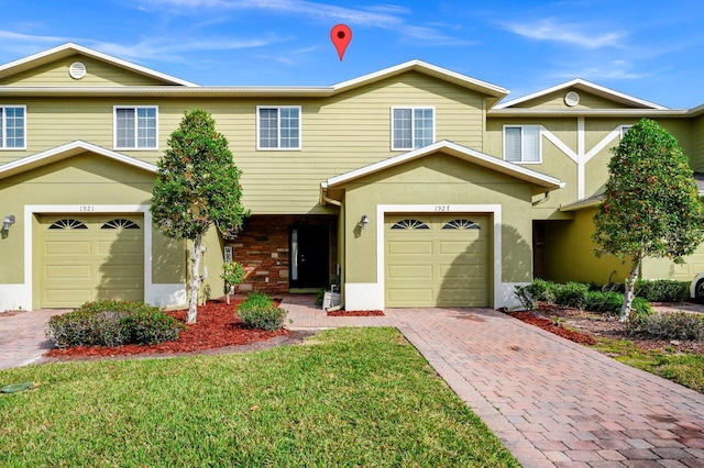 view of property featuring a garage and a front yard