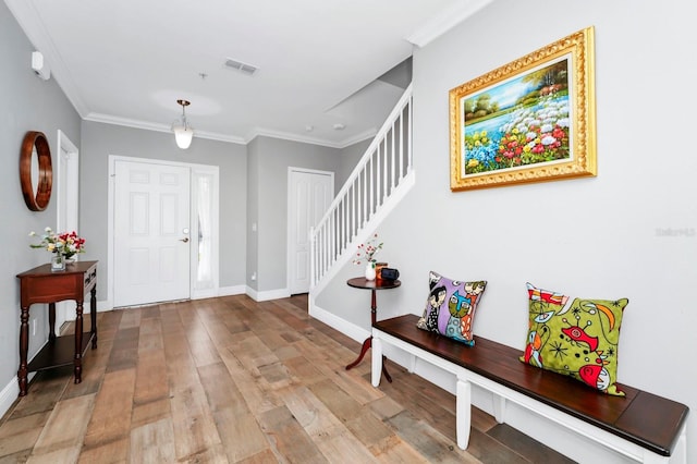 entrance foyer with ornamental molding and hardwood / wood-style floors