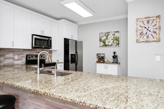 kitchen with backsplash, white cabinets, light stone counters, kitchen peninsula, and stainless steel appliances