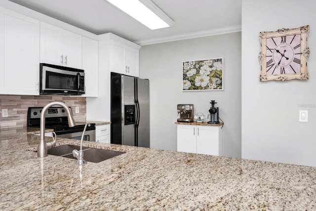 kitchen featuring white cabinetry, appliances with stainless steel finishes, backsplash, and light stone counters