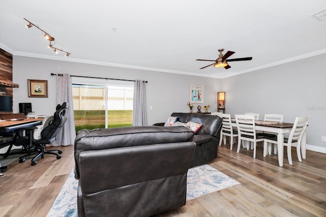 living room with crown molding, ceiling fan, and light wood-type flooring