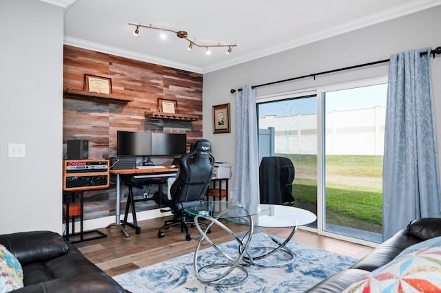 home office with track lighting, ornamental molding, hardwood / wood-style floors, and wood walls