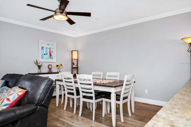 dining room featuring hardwood / wood-style floors, crown molding, and ceiling fan