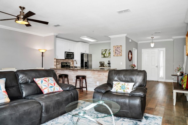 living room featuring ceiling fan, ornamental molding, dark hardwood / wood-style flooring, and sink