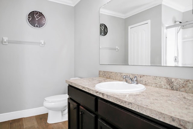 bathroom featuring hardwood / wood-style flooring, crown molding, vanity, and toilet