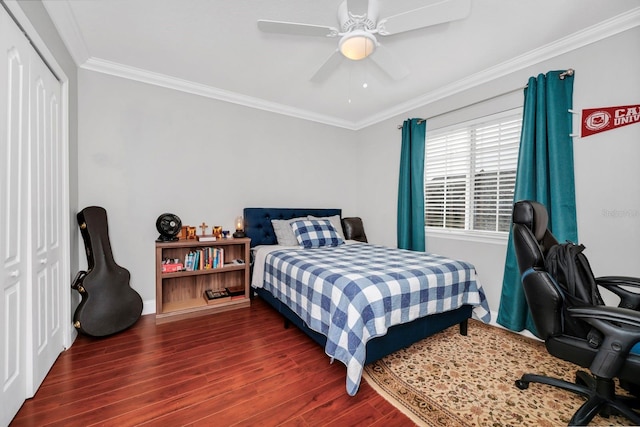 bedroom with ornamental molding, ceiling fan, dark hardwood / wood-style flooring, and a closet