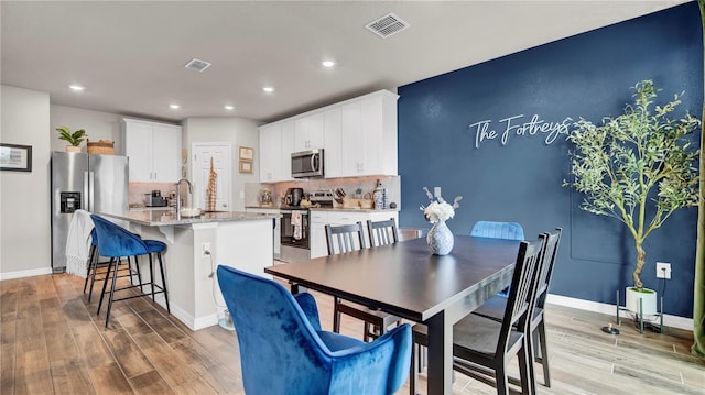 dining space featuring sink and light hardwood / wood-style flooring