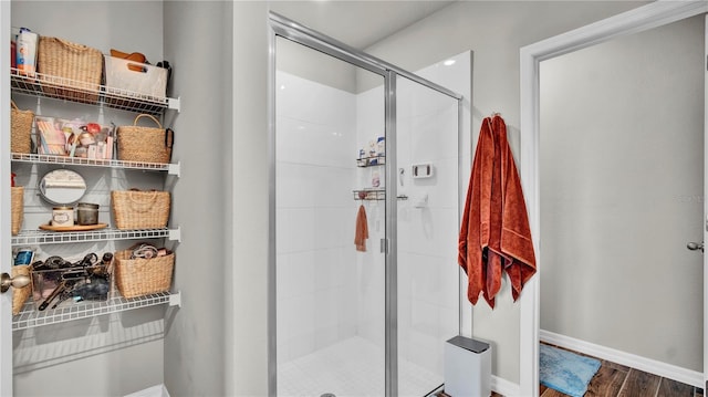 bathroom featuring a shower with door and hardwood / wood-style flooring