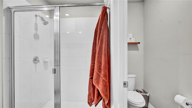 bathroom with an enclosed shower and toilet