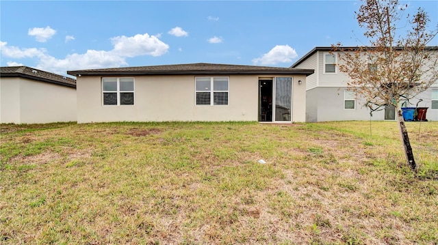 rear view of property featuring a lawn