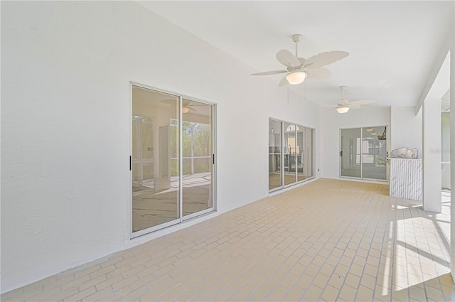 unfurnished sunroom featuring ceiling fan