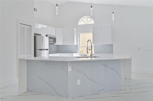 kitchen featuring stainless steel appliances, white cabinetry, and decorative light fixtures