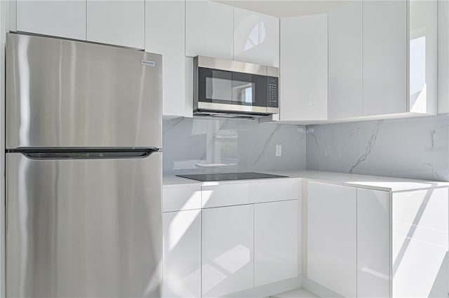 kitchen featuring white cabinetry, appliances with stainless steel finishes, and tasteful backsplash