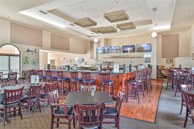 dining space featuring a tray ceiling and a high ceiling