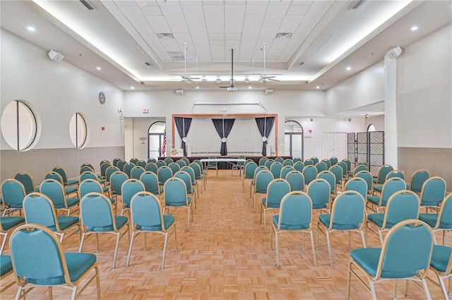 misc room featuring a drop ceiling, a towering ceiling, a raised ceiling, and light parquet flooring