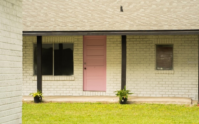 entrance to property with a lawn