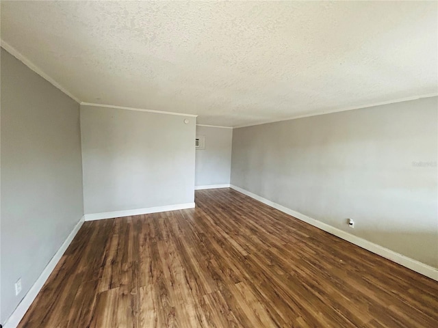 empty room featuring dark hardwood / wood-style flooring, ornamental molding, and a textured ceiling