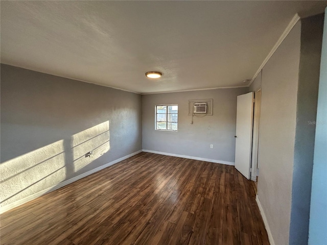 empty room with dark hardwood / wood-style flooring, ornamental molding, and a wall mounted AC