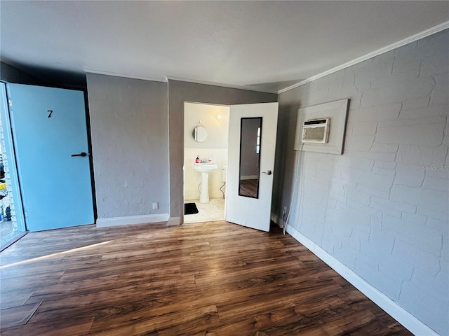 empty room featuring sink, crown molding, dark wood-type flooring, and a wall unit AC