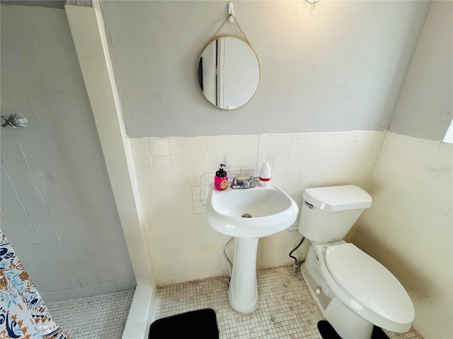 bathroom featuring toilet, tile walls, tile patterned floors, and walk in shower