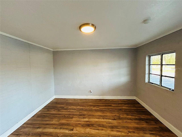 spare room with ornamental molding and dark hardwood / wood-style floors