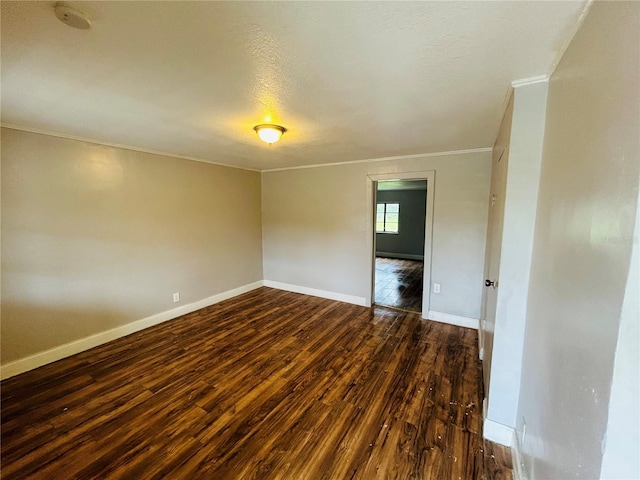 spare room featuring dark hardwood / wood-style flooring, crown molding, and a textured ceiling