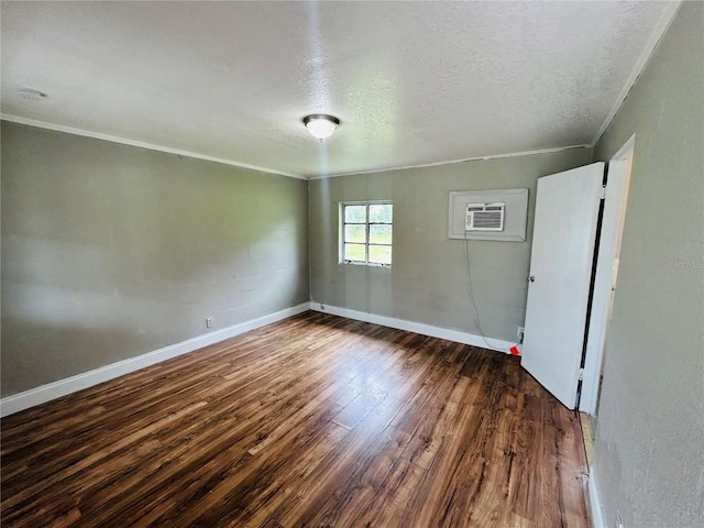 empty room featuring crown molding, dark hardwood / wood-style floors, a wall mounted AC, and a textured ceiling