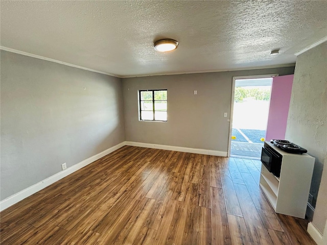 spare room with crown molding, hardwood / wood-style flooring, a wealth of natural light, and a textured ceiling