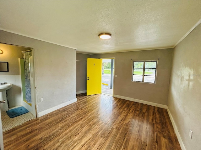 spare room with ornamental molding, hardwood / wood-style floors, and a textured ceiling