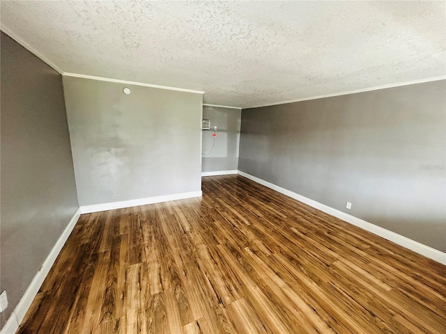 unfurnished room with crown molding, wood-type flooring, and a textured ceiling